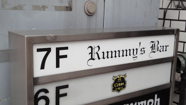 a sign reads 7F Rummy's Bar